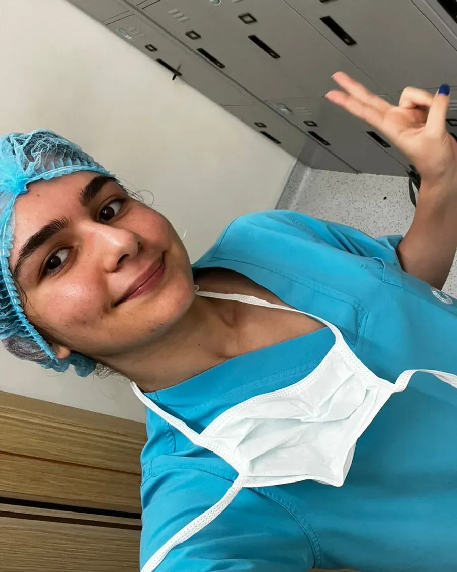 Jana in surgical scrubs and a cap during a hospital placement.